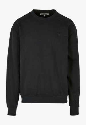 Melna sudrabota krekla jaka, kas izgatavota no kokvilnas maisījuma, ar noapaļotu kaklu, ribotām piedurknēm un diskrētu logotipu uz krūtīm. Gluda tekstūra un brīva piegriezuma.