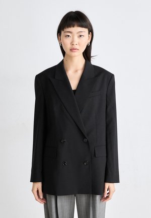 Black double-breasted blazer with notch lapels, two front pockets, and black buttons. Smooth fabric with structured silhouette.