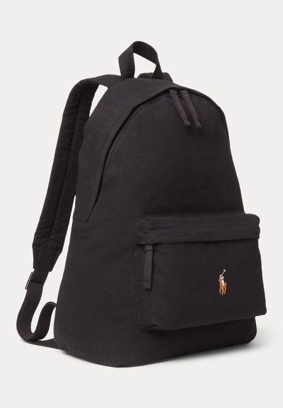 Mochila de tela negra con correas acolchadas, bolsillo frontal con cremallera y pequeño logo bordado de jugador de polo en el bolsillo.