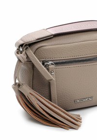 Béžová kožená crossbody taška s texturovaným povrchem, vybavená stříbrnými kovovými doplňky, zipovou přední kapsou a dekorativním třásním.