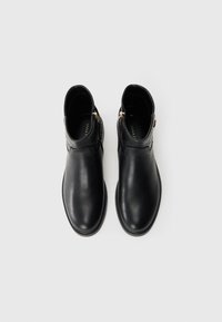 Stivali alla caviglia in pelle nera con finitura liscia, punta tonda e zip laterale. Presentano una texture contrastante vicino alla caviglia e poche componenti metalliche.
