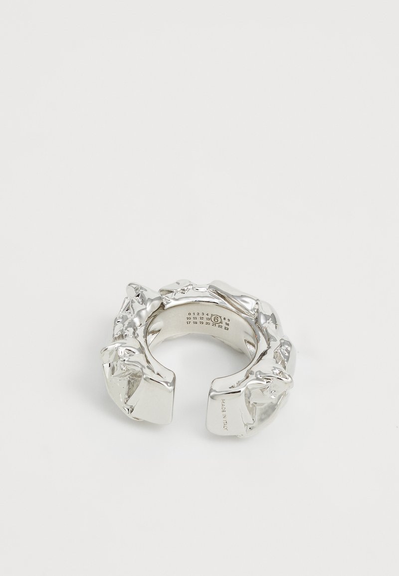 Bague en argent avec un design texturé et abstrait, présentant des extrémités ouvertes et des marquages de taille gravés sur la bande intérieure.