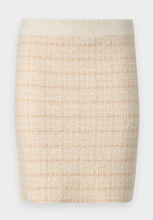 Jupe mini en tricot beige avec un motif à carreaux texturé, dotée d'une taille unie couleur crème. Longueur mi-cuisse, tissu doux.
