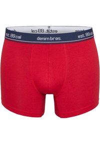 Boxer-briefs en coton rouge avec une ceinture élastique bleu marine arborant un texte blanc. Conçues avec une poche contournée et des coutures à plat pour le confort.