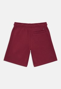 Bordeaux bomuldsbukser med elastisk talje, der har en enkelt baglomme og et diskret brandlogo.