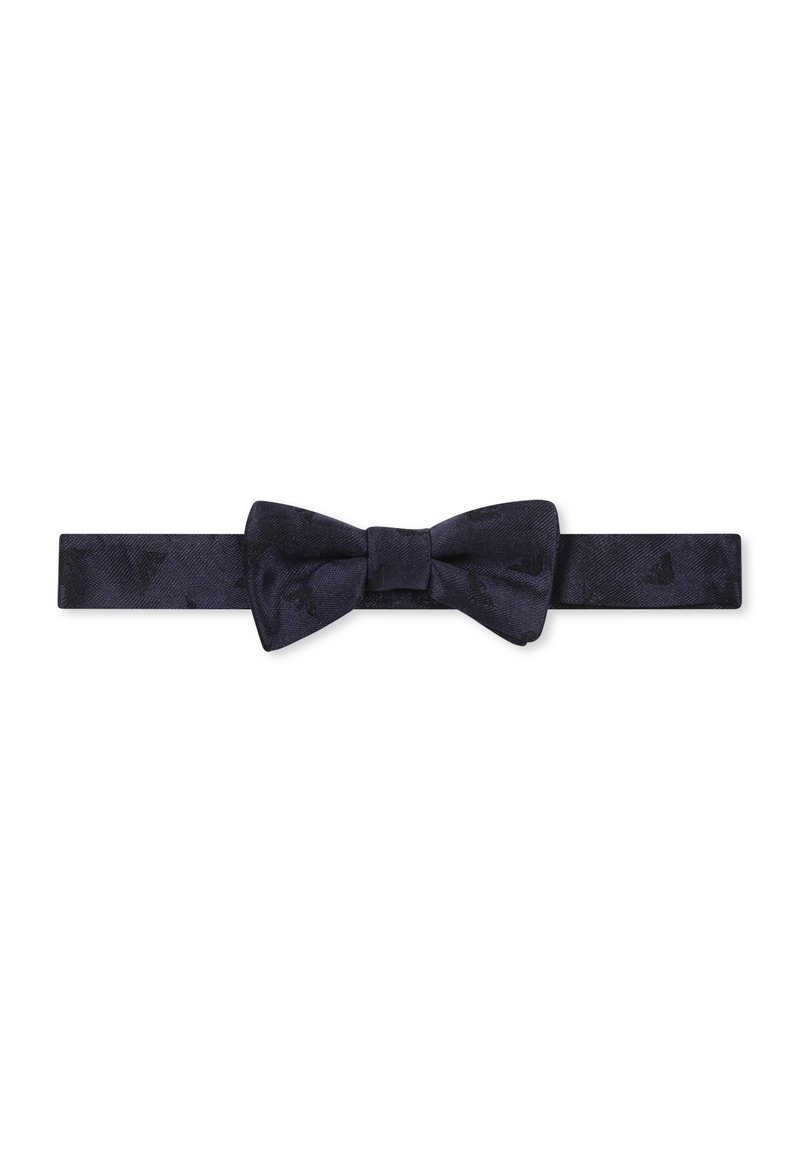Papillon di seta blu navy con un motivo testurizzato. Presenta un nodo centrale e una tracolla regolabile per adattarsi a diverse misure.