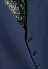 Marineblaues Sakko mit glatter Textur, ausgestattet mit einem gemusterten schwarz-grauen Futter und fünf schwarzen Knöpfen auf der Vorderseite.