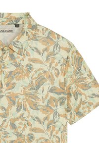 Kortärmad polo skjorta i ljusgul med ett blommönster som har orange, gröna och svarta ränder. Inkluderar en krage och knappar.