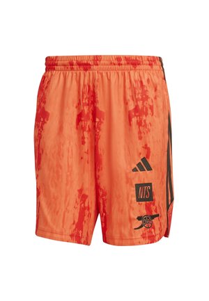 Shorts de sport orange vif avec un motif ondulé, présentant des accents noirs, une taille élastique et des logos sur les côtés. Tissu léger.