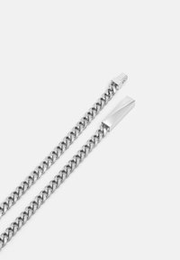 Sølvkjede med kraftige lenker og en polert rektangulær lås. Har en glatt, metallisk overflate og en holdbar design.