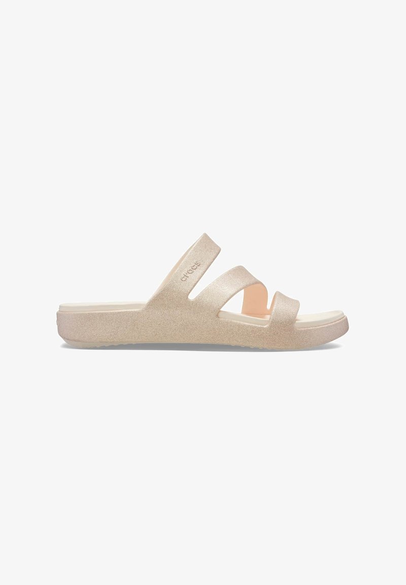 Sandalia abierta con brillo en beige claro, con tres tiras anchas y suela plana, diseñada para uso casual.