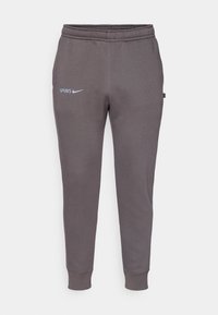 Graue Jogginghose aus weichem Material, mit elastischem Bund, tapered Bein und dem Text "SPURS" sowie einem Nike-Logo in hellblau.