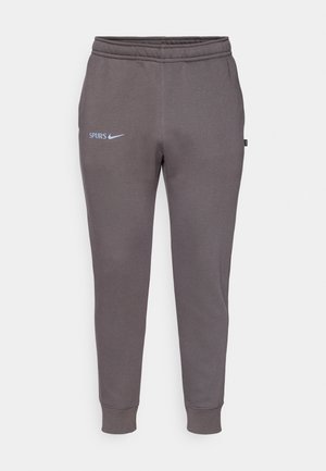 Grå sweatpants gjorda av mjukt material, med elastisk midja, avsmalnande ben och texten "SPURS" tillsammans med ett Nike-logotyp i ljusblått.
