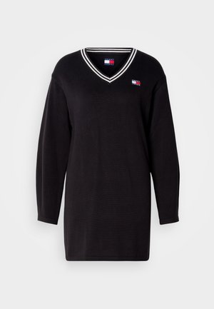 Czarny sweter z długim rękawem, z dekoltem w serek i białymi paskami. Posiada małe logo na lewej piersi. Wykonany z dzianiny.