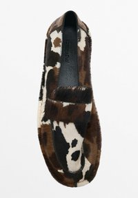 Loafer-style shoe with brown, black, and white cowhide pattern and a matching strap across the top, set against a plain white background.