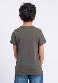 T-shirt à manches courtes vert olive avec un col rond, fabriqué en tissu doux. La vue de dos montre un design simple, sans motifs ni détails supplémentaires.