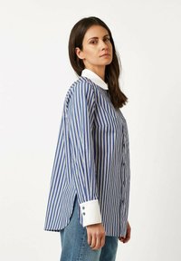 Blue and white vertically striped long-sleeve shirt with a white collar, button-up front, and cuffs featuring two buttons.