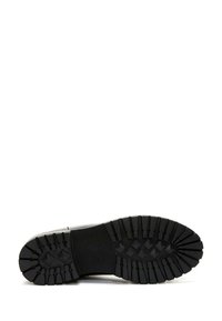 Black rubber footwear sole featuring deep, angular treads and a textured midsole. Durable design suited for various terrains.
