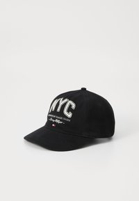 Black baseball cap with a curved brim, featuring white embroidered "NYC" text and "American Classic Goods" below. Textile material, no patterns.