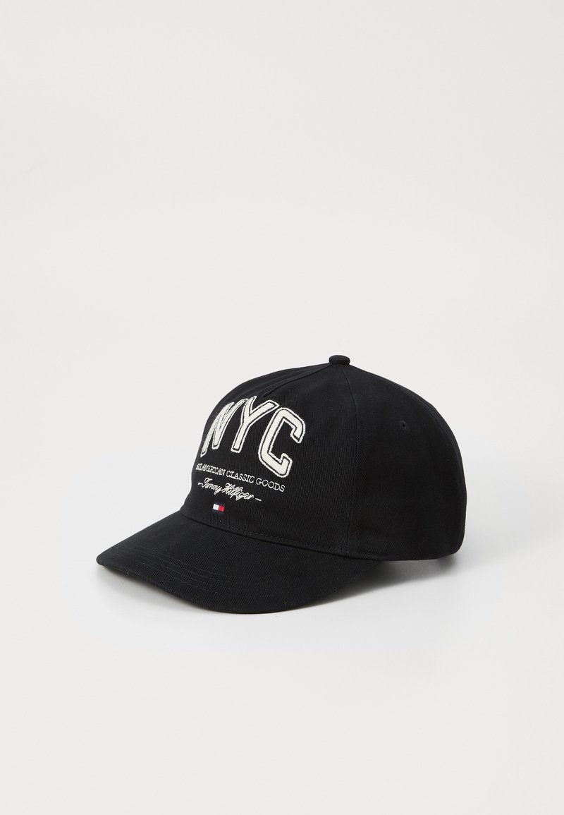 Black baseball cap with a curved brim, featuring white embroidered "NYC" text and "American Classic Goods" below. Textile material, no patterns.
