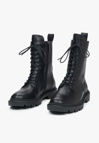 Czarne skórzane botki za kostkę z sznurowaniem z przodu, zamkiem błyskawicznym z boku oraz wytrzymałymi gumowymi podeszwami. Posiadają gładkie wykończenie i wzmocnione przeszycia.