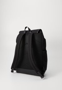 Black backpack with a sleek, minimalist design. Features padded mesh shoulder straps and a roll-top closure, made from durable fabric.