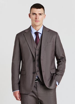 Completo marrone a fantasia con revers a punte, indossato su una camicia azzurro chiaro. Dettagli notevoli includono un gilet con tre bottoni e una cravatta bordeaux.