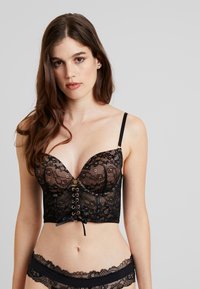 Svart blonde bralette med dyp utringning, front med snøring i blonde og gullakenter, samt justerbare stropper. Myk, teksturert stoff.