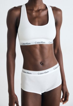 Set di reggiseno e mutande Calvin Klein bianche. Il reggiseno ha un collo a giro, mentre le mutande presentano un elastico con logo. Tessuto di cotone liscio e elasticizzato.