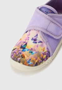 Lila tygsko med en spets- och blommig tryckt tåhuvud. Designen inkluderar ett kardborreband och en texturerad gummisula.