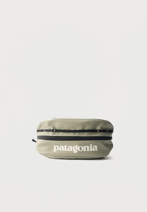 Petite pochette zippée vert olive avec des accents noirs et le logo "patagonia" blanc centré sur l'avant.
