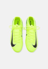 Jasně žluté fotbalové kopačky s texturovaným designem, černý znak Nike a odpovídající tkaničky; lehká konstrukce pro výkon.