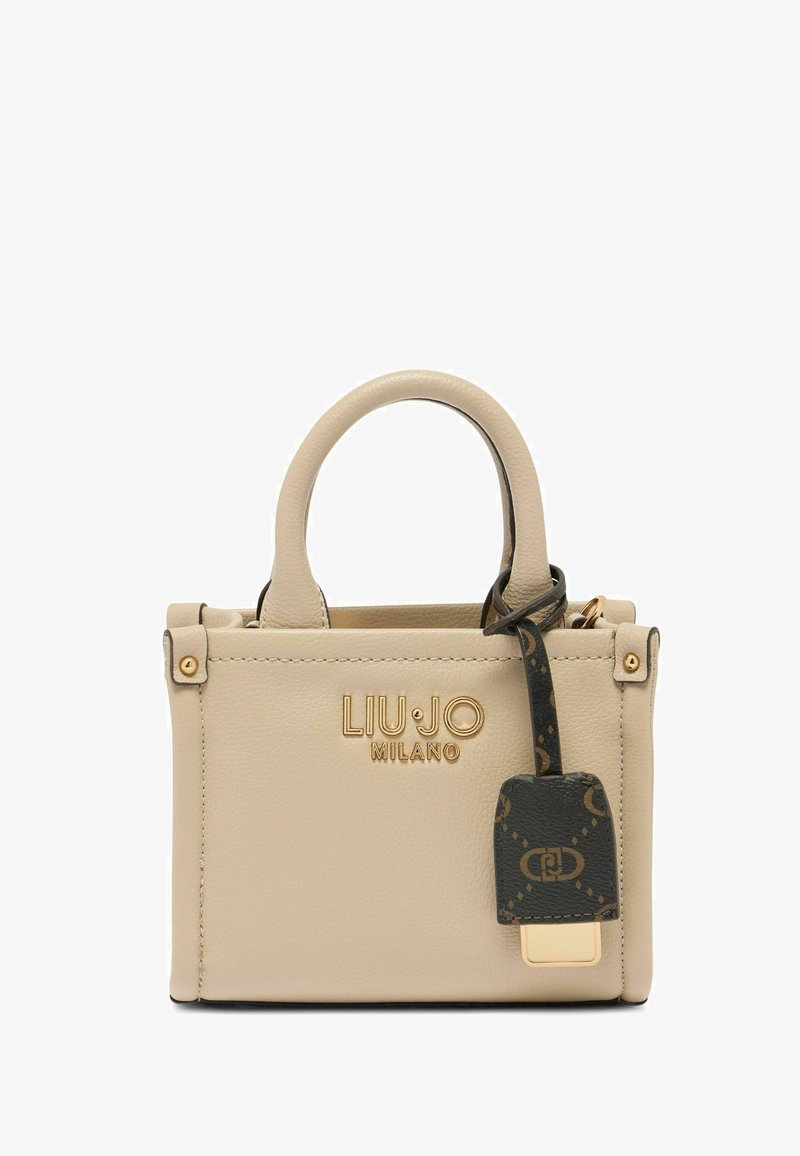 Beige leren handtas met gouden branding, twee korte handvatten en een zwarte label met een patroon. Compact rechthoekig ontwerp met een gladde textuur.