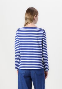Blue and white striped long-sleeve shirt with a boat neckline, soft fabric, and a relaxed fit. Back design features a straight hem.
