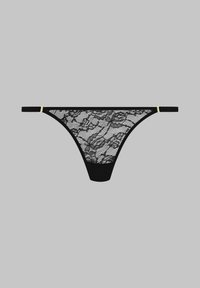 String noir en dentelle avec un motif floral, présentant un tissu noir à l'avant et des fines lanières rehaussées de matériel jaune.