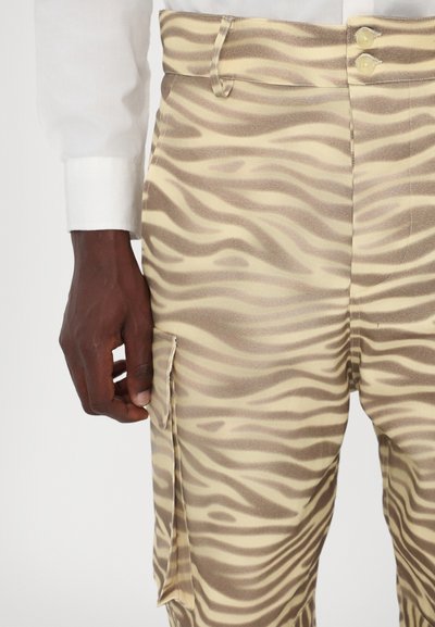 Broek in een beige en bruine zebra-streep patroon, met een rechte snit, twee knopen en een zijzak met flap.