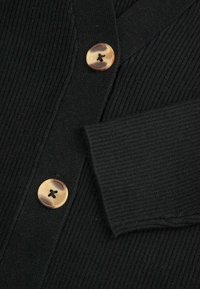 Czarny kardigan prążkowany z dwoma okrągłymi, nakrapianymi brązowymi guzikami oraz teksturowanym materiałem. Szczegóły podkreślają kołnierz i mankiety.