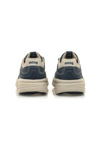 Zapatillas en tonos azul marino y beige con un diseño texturizado, que cuentan con una suela gruesa, talón reforzado y un logo impreso en la parte trasera.