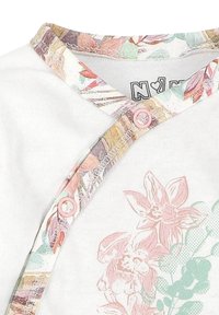 Biała odzież z kolorowym kołnierzem w kwiaty i różowymi zatrzaskami. Projekt zawiera stonowane różowe kwiaty i zielone akcenty. Miękki materiał bawełniany.