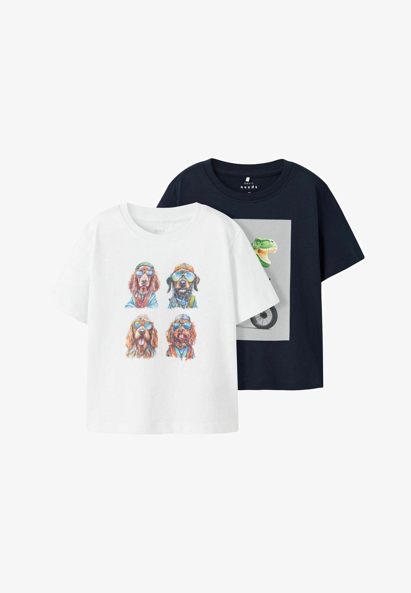 Dvě trička s krátkým rukávem: jedno bílé s ilustracemi psů ve slunečních brýlích, druhé tmavě modré s grafikou dinosaura v čtvercovém rámečku.