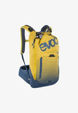Sac à dos de randonnée jaune et bleu avec logo « evoc », bretelles rembourrées, ceinture à la taille, poche avant en filet et lunettes de soleil accrochées à la fermeture éclair du dessus.