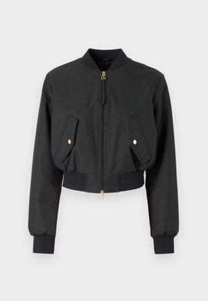 Zwarte cropped bomberjack gemaakt van gladde stof, met een voorrits, gouden hardware, en twee klepzakken met gouden knopen.