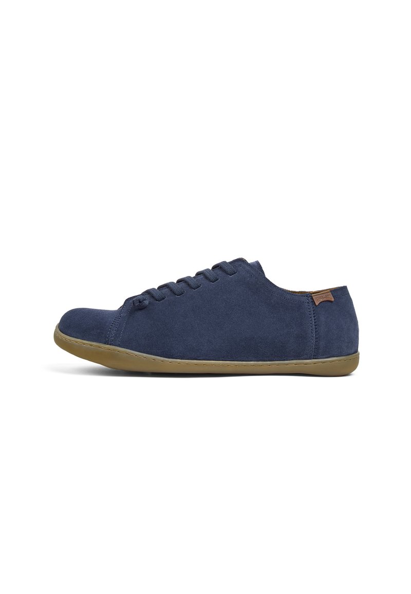 Navy suede sneakers with a low profile, round toe, and flat rubber sole. Features a simple lace-up design and a small brown accent tag.