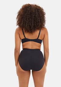 Ensemble de soutien-gorge noir et culotte taille haute. Tissu lisse, bretelles réglables et bords festonnés à la taille. Vue arrière.