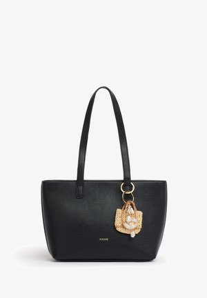 Zwarte leren tote tas met lange handvatten, klein geweven hangertje versierd met schelpen en parels, hangend aan één handvat.