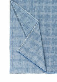 Tessuto intrecciato di colore azzurro chiaro con una superficie testurizzata e decorata. I bordi mostrano dettagli sfilacciati, evidenziando la morbidezza e il design del tessuto.