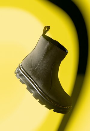 Grå lær ankle boot med teksturert finish, avrundet tå og solid svart gummisåle med zigzag-mønster og gul kontrastsøm.
