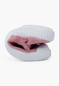 Haut en tissu texturé rose avec semelle en caoutchouc blanche, chaussure pliée, montrant la doublure intérieure et le détail élastique. Design à bout rond.
