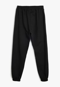 Zwarte relaxte sweatpants met een elastische tailleband, geribbelde enkelboorden en een gladde, lichte stof. Geen zichtbare zakken.