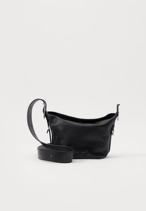 Petit sac bandoulière en cuir noir avec sangle ajustable et boucle argentée, présenté sur un fond blanc uni.